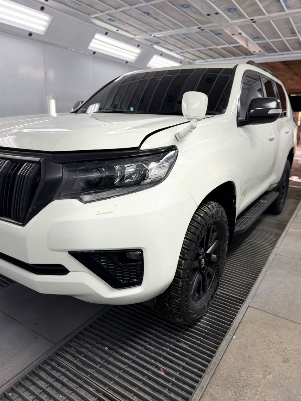 Technician performing machine paint correction on a car exterior at DOP Respray in Karen